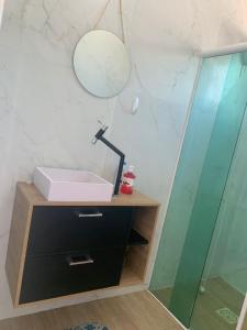 ein Badezimmer mit Waschbecken und Glasdusche in der Unterkunft Recanto Andrade in Governador Celso Ramos