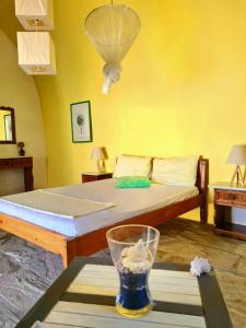1 dormitorio con 1 cama y un jarrón sobre una mesa en Maisonnette Flo Mitata, en Mitáta