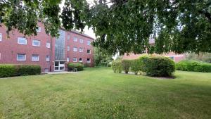een grote groene tuin voor een bakstenen gebouw bij Fewo Flutbarke in Wilhelmshaven