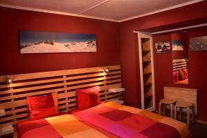 Schlafzimmer mit roten Wänden und einem Bett mit roten Kissen in der Unterkunft Adventure Hostel in Klosters