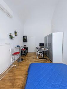 Camera con letto, tavolo e frigorifero. di Botanique Rooms a Bologna