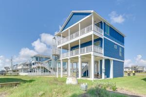 Una gran casa azul con molduras blancas en una playa. en Modern Galveston Vacation Rental Steps to Beach!, en Galveston