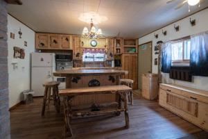 a kitchen with a table and a refrigerator at Black bear cabin with blow up hot tub in Necedah +4 photos