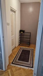 a hallway with a black and white rug in a room at JM Apartman in Donja Vrežina