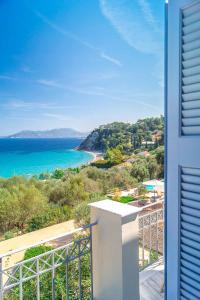 a view of the ocean from the balcony of a house at Armonia Bay Hotel in Kokkari