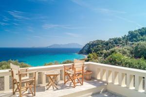 a balcony with chairs and a view of the ocean at Armonia Bay Hotel in Kokkari