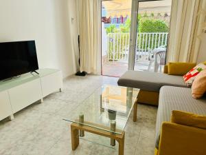 a living room with a couch and a tv and a table at Playa del Cura in Playa del Cura