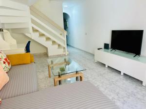a living room with a couch and a flat screen tv at Playa del Cura in Playa del Cura