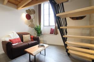 a living room with a couch and a stair at Le duplex du 71 B in Niort