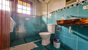 a bathroom with a toilet and a glass shower at Manacá Suítes Prumirim in Ubatuba +52 photos
