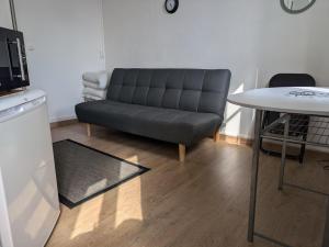 a living room with a couch and a table at L'Opale, studette 2 in Berck-sur-Mer