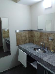 a bathroom with a sink and a mirror at Cabañas ALTOS DEL MOLLE en VCP in Villa Carlos Paz