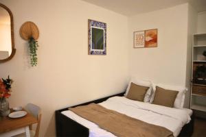 En eller flere senge i et værelse på Charmant Appartement à Paris 2P