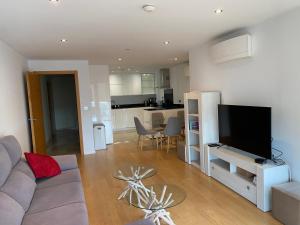 a living room with a couch and a flat screen tv at Family apartment with swimming pools 3 bedroom 2 bathroom Rock facing in Gibraltar