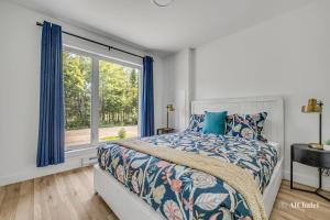 ein Schlafzimmer mit einem Bett und einem Fenster in der Unterkunft Le Milos - Escapade paisible - Animaux bienvenus in Sainte-Catherine