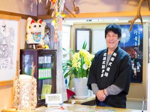 ein Mann steht hinter einer Theke in einem Geschäft in der Unterkunft Dorogawa Onsen Ryokan Kuboji - Vacation STAY 87119v in Tenkawa