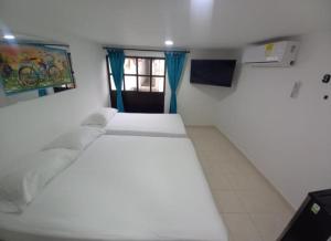 a bedroom with a white bed and a window at Hostal Doña Betty 2 in Cartagena de Indias