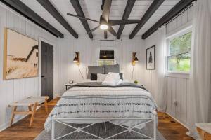 a bedroom with a bed in a white room at NEW Toccoa River Front - HotTub Fire pit Game Room in Mineral Bluff