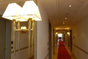 a hallway with a red carpet and a light fixture at Grand Hotel Duca Di Mantova in Sesto San Giovanni