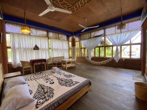 a bedroom with a bed in a room with windows at Casa Madre Selva in Brisas de Zicatela +47 photos