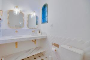 een witte badkamer met 2 spiegels en een wastafel bij Elsi Pousada in Búzios +71 foto's