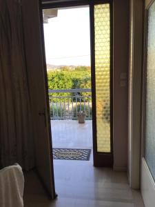 an open door to a balcony with a view at Lidas Golden View-All around veranda apartment in Nafplio