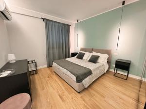 马尔科西蒙尼HOLIDAYS HOMES ROME GOLF Appartamenti Marco Simone AeB的一间卧室配有一张床、一张桌子和一张四柱床。