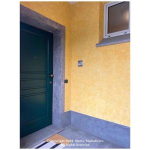 una puerta verde en el costado de un edificio en appartamento dolcevita, en Alba