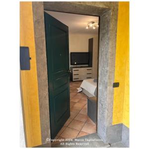 una puerta verde que conduce a un dormitorio con cama en appartamento dolcevita, en Alba