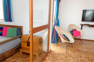 a bedroom with a bunk bed and two chairs at troje tradicional purépecha -live the experince- in Morelia