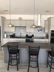 a kitchen with three chairs and a table with a counter at Hideaway in a Luxurious Location in Saint Robert