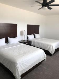 a hotel room with two beds and a ceiling fan at Hideaway in a Luxurious Location in Saint Robert