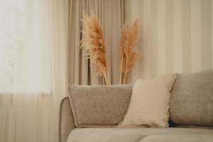 a couch with some feathers on the back of it at Haustory Apartment in Klaipėda