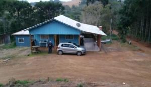 a car parked in front of a blue house at Rancho do Pijuca - Usina Mauá in Ortigueira