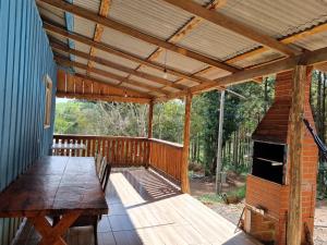 a wooden deck with a wooden table and a wooden roof at Rancho do Pijuca - Usina Mauá in Ortigueira