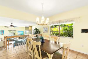 a dining room and living room with a table and chairs at Siesta Key Village, Heated Pool, Beach Access 4 min Walk, 3bdr in Siesta Key