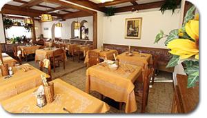 カンピテッロ・ディ・ファッサにあるHotel Primulaの木製テーブルとダイニングルームのあるレストラン