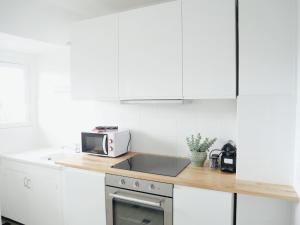 a white kitchen with a sink and a microwave at L'échappée Deauvillaise - Entièrement Rénové en 2025 in Deauville