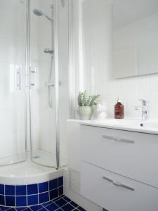 a white bathroom with a shower and a blue tile floor at L'échappée Deauvillaise - Entièrement Rénové en 2025 in Deauville