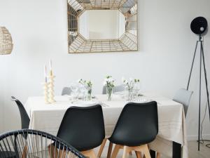 a white table with black chairs and a mirror at L'échappée Deauvillaise - Entièrement Rénové en 2025 in Deauville