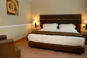 a bedroom with a large bed and a chair at Grand Hotel Duca Di Mantova in Sesto San Giovanni