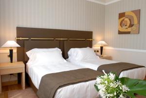 two beds in a hotel room with two lamps at Grand Hotel Duca Di Mantova in Sesto San Giovanni