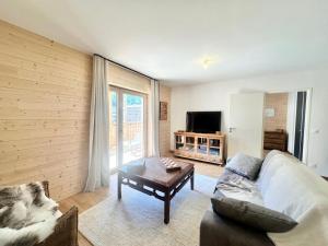 a living room with a couch and a table at Résidence Le Living Stone B - LE LIVING STONE-Tout inclus MAE-1811 in Vars