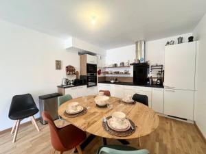a kitchen with a wooden table and chairs in a room at Résidence Le Living Stone B - LE LIVING STONE-Tout inclus MAE-1811 in Vars