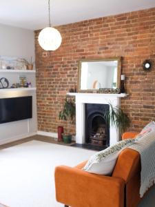 a living room with a couch and a brick wall at Penthouse Seaview Warrior Square in Hollington