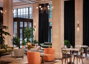 a lobby with tables and chairs and windows at ROOST Detroit in Detroit
