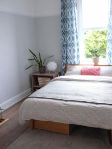 a bedroom with a bed and a window with blue curtains at Penthouse Seaview Warrior Square in Hollington