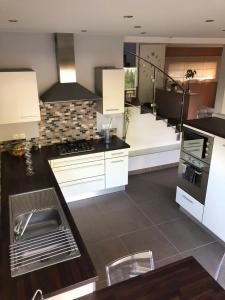 a kitchen with white cabinets and a counter top at Chalet Sapinou in Les Deux Alpes +17 photos