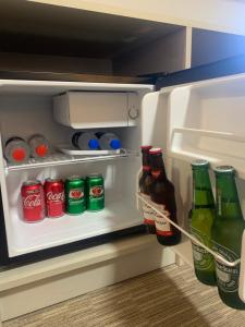 an open refrigerator filled with bottles of soda at Pousada Clementine in Gramado