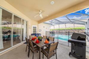 ein Esszimmer mit einem Tisch und einem Grill in der Unterkunft Villa Mona, 4bed pool, Hot tub,Game Room at Calabay Tower lake in Haines City